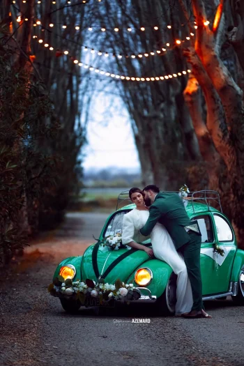 Couple de mariés devant une voiture Coccinelle de collection au Domaine du Petit Malherbes, capturé par Stéphanie Azémard.