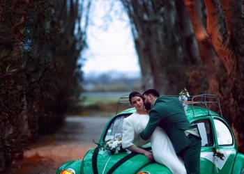 Couple de mariés devant une voiture Coccinelle de collection au Domaine du Petit Malherbes, capturé par Stéphanie Azémard.